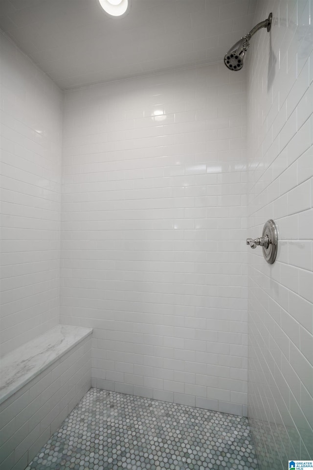 bathroom featuring tiled shower and tile patterned flooring