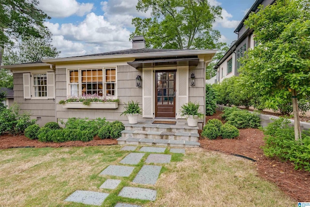 view of front of home with a front lawn and a chimney