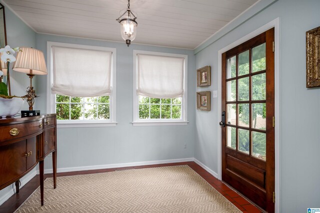 doorway to outside with ornamental molding and baseboards