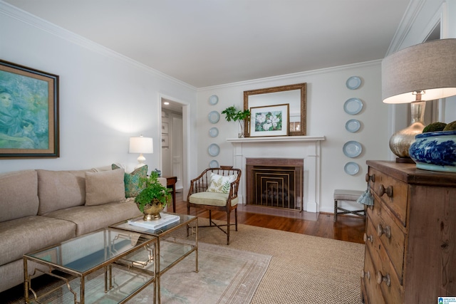 living room featuring ornamental molding, a fireplace with flush hearth, and wood finished floors