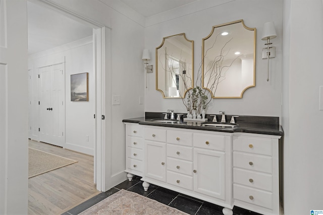 bathroom featuring double vanity, a sink, and baseboards