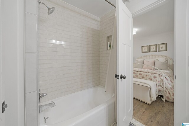 ensuite bathroom featuring connected bathroom, crown molding, tub / shower combination, and wood finished floors