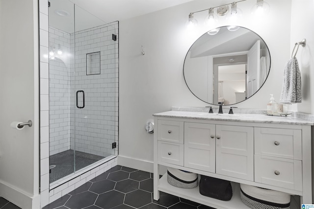 bathroom with baseboards, tile patterned floors, a stall shower, and vanity
