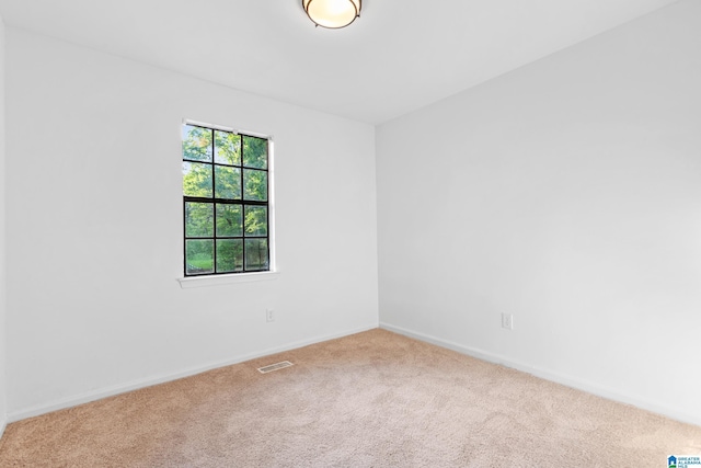 empty room featuring visible vents, baseboards, and carpet floors