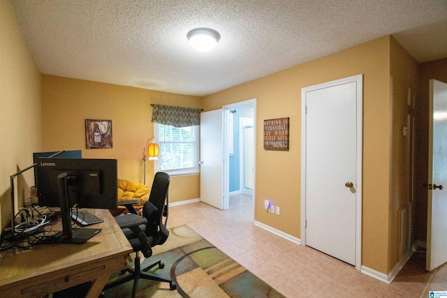 office area featuring light tile patterned floors, baseboards, and a textured ceiling