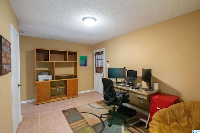 office space featuring light tile patterned floors, a textured ceiling, and baseboards