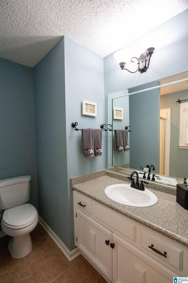 bathroom featuring tile patterned flooring, a textured ceiling, toilet, and vanity