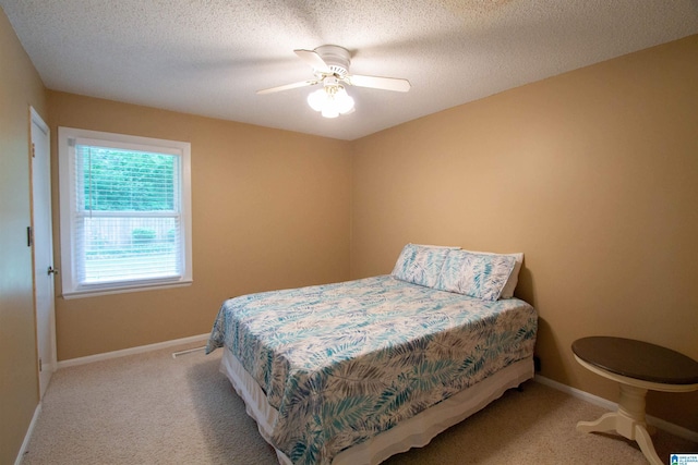 carpeted bedroom featuring baseboards, ceiling fan, and a textured ceiling