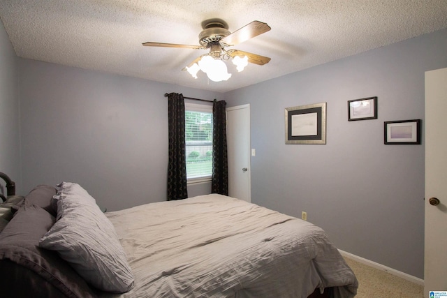 carpeted bedroom featuring baseboards, a textured ceiling, and ceiling fan