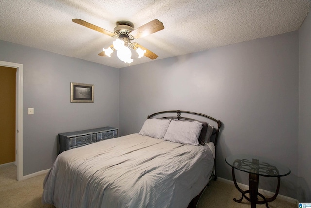 bedroom with baseboards, a textured ceiling, ceiling fan, and light carpet