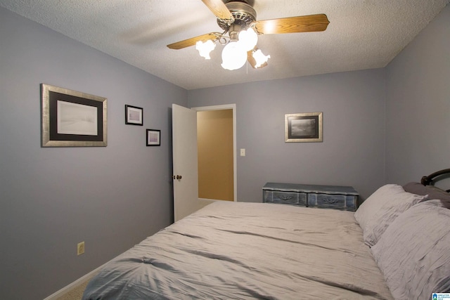 carpeted bedroom featuring baseboards, a textured ceiling, and ceiling fan