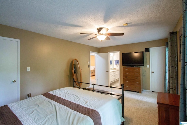 bedroom featuring ensuite bathroom, a ceiling fan, a textured ceiling, and light carpet