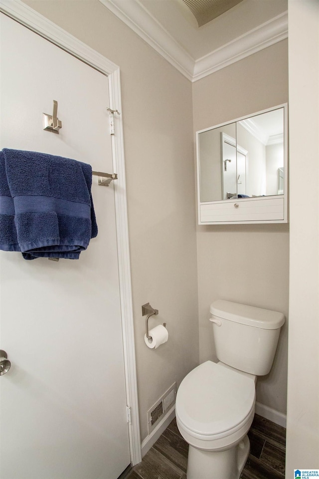 bathroom with visible vents, crown molding, wood finished floors, and toilet