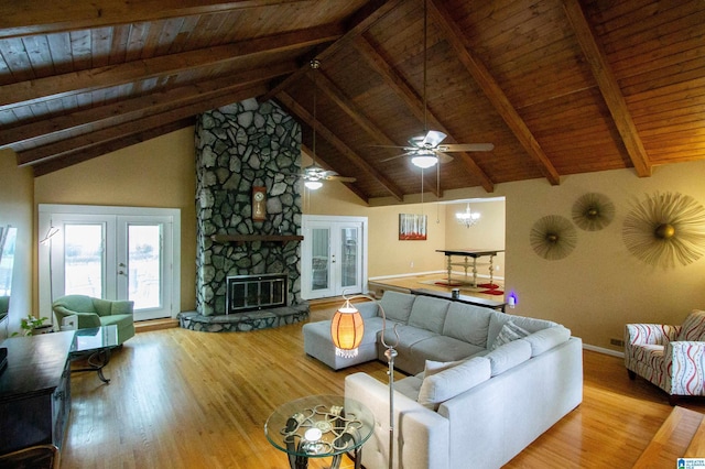 living area with baseboards, lofted ceiling with beams, wooden ceiling, and wood finished floors