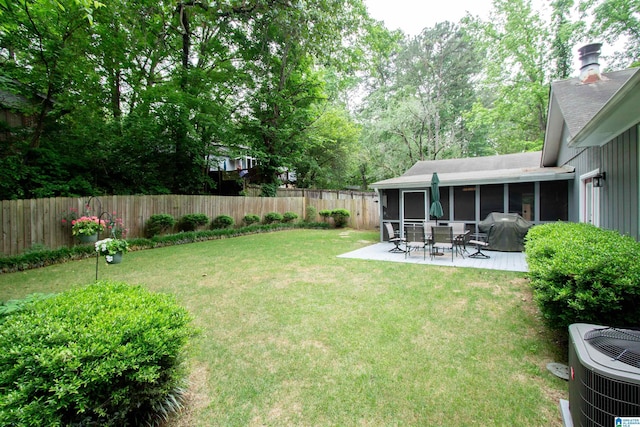 view of yard featuring a sunroom, a fenced backyard, a patio area, and cooling unit