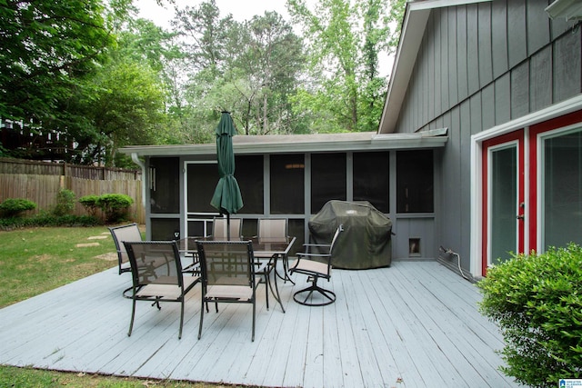 wooden terrace featuring a sunroom, outdoor dining area, fence, and area for grilling