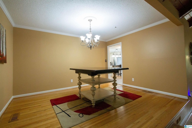 dining area featuring a textured ceiling, visible vents, crown molding, wood finished floors, and baseboards
