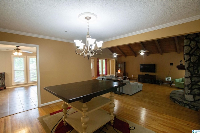 dining area featuring crown molding, ceiling fan with notable chandelier, light wood-type flooring, and a textured ceiling