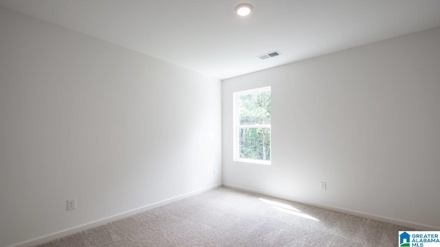 carpeted spare room with baseboards and visible vents