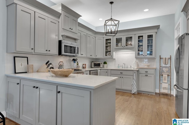 190 Drennen Park Cir, Hayden, AL 35079 - kitchen featuring stainless steel appliances, a peninsula, a chandelier, backsplash, and pendant lighting