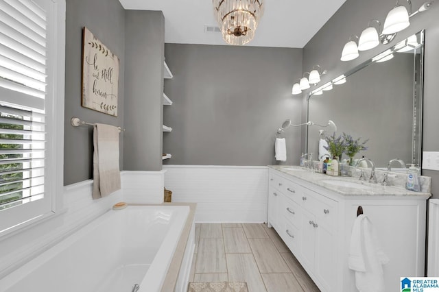 190 Drennen Park Cir, Hayden, AL 35079 - full bath featuring a chandelier, double vanity, a bath, and a wainscoted wall