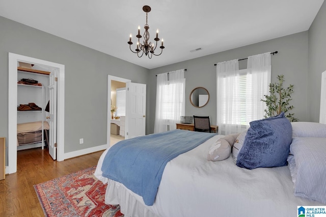 190 Drennen Park Cir, Hayden, AL 35079 - bedroom featuring a chandelier, wood finished floors, a spacious closet, baseboards, and ensuite bathroom
