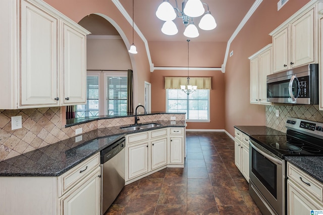 kitchen featuring a sink, a wealth of natural light, stainless steel appliances, and a chandelier