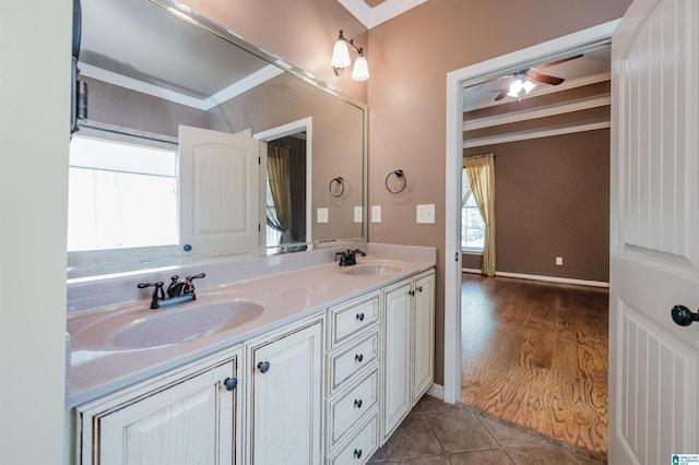 bathroom with double vanity, a sink, a ceiling fan, and ornamental molding