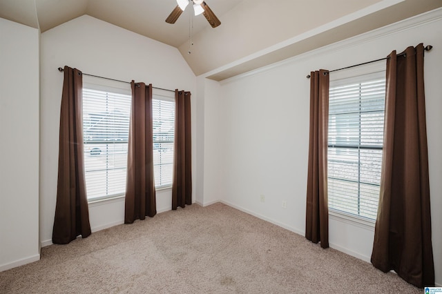 carpeted empty room with baseboards, ceiling fan, vaulted ceiling, and a healthy amount of sunlight