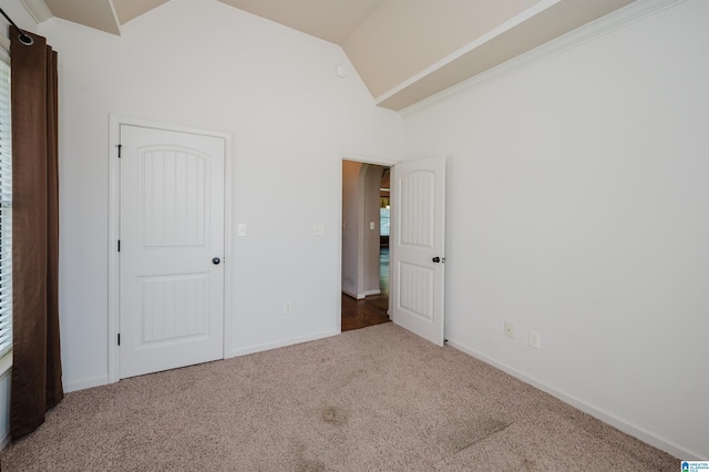 unfurnished bedroom with baseboards, carpet, and vaulted ceiling