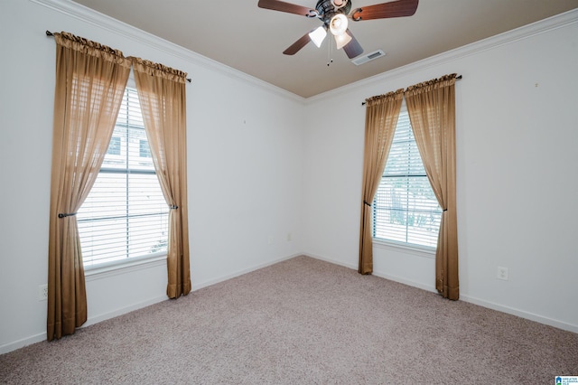 empty room with ceiling fan, visible vents, ornamental molding, and carpet