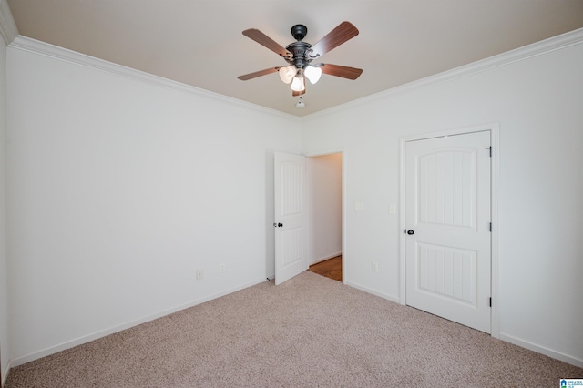 unfurnished bedroom with crown molding, baseboards, carpet, and a ceiling fan