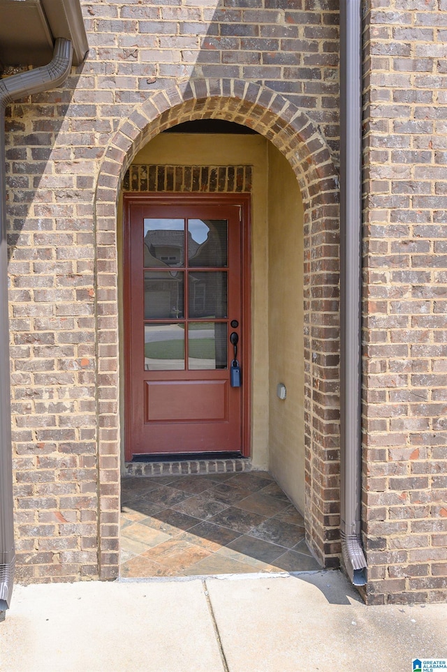 view of exterior entry with brick siding