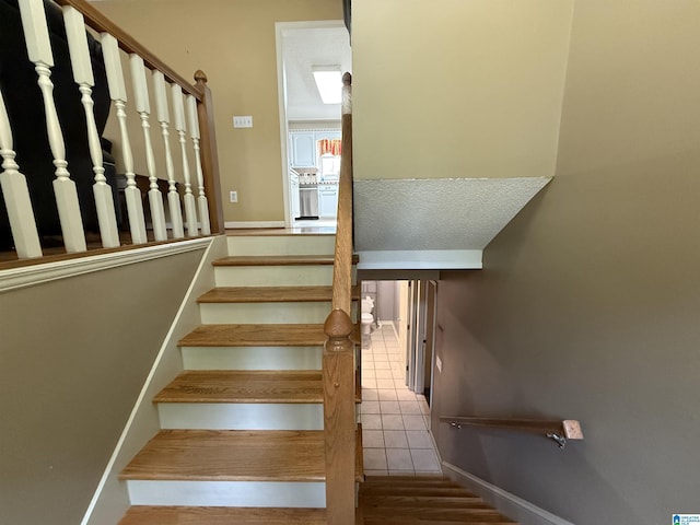 stairs featuring baseboards and tile patterned floors