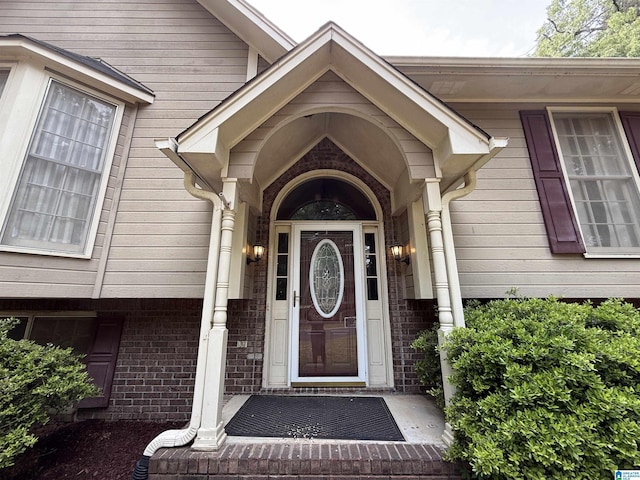 view of exterior entry featuring brick siding
