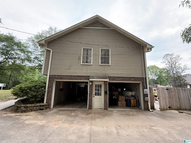 exterior space featuring concrete driveway, brick siding, and a garage