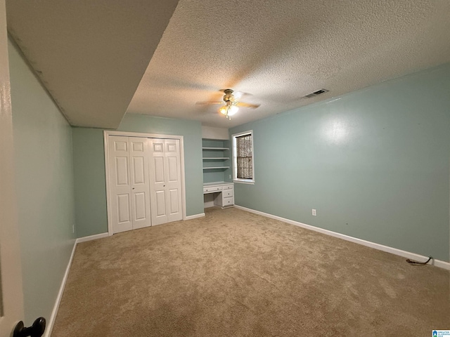 96 Tomahawk Cir, Pelham, AL 35124 - unfurnished bedroom with carpet flooring, a textured ceiling, a closet, ceiling fan, and a desk