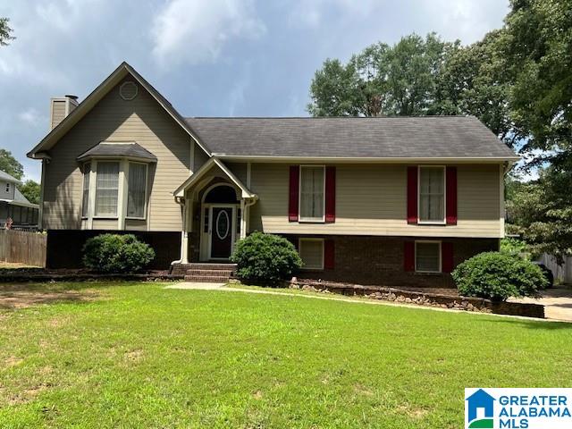 96 Tomahawk Cir, Pelham, AL 35124 - raised ranch featuring a front yard and a chimney