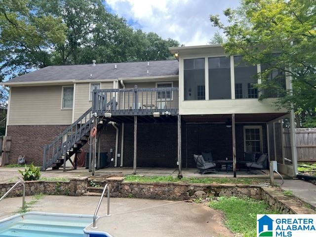 96 Tomahawk Cir, Pelham, AL 35124 - rear view of property with a patio, stairway, a wooden deck, brick siding, and an outdoor pool
