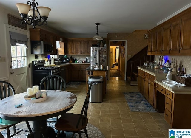 1003 Old Samaria Rd, Clanton, AL 35045 - kitchen featuring tasteful backsplash, hanging light fixtures, an inviting chandelier, appliances with stainless steel finishes, and a kitchen island