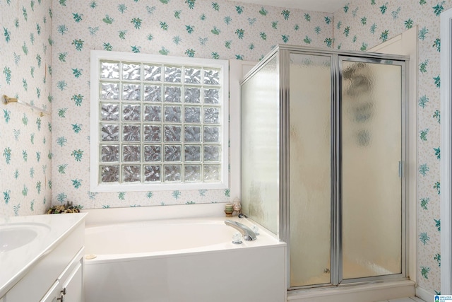 bathroom featuring a shower stall, a bath, wallpapered walls, and vanity