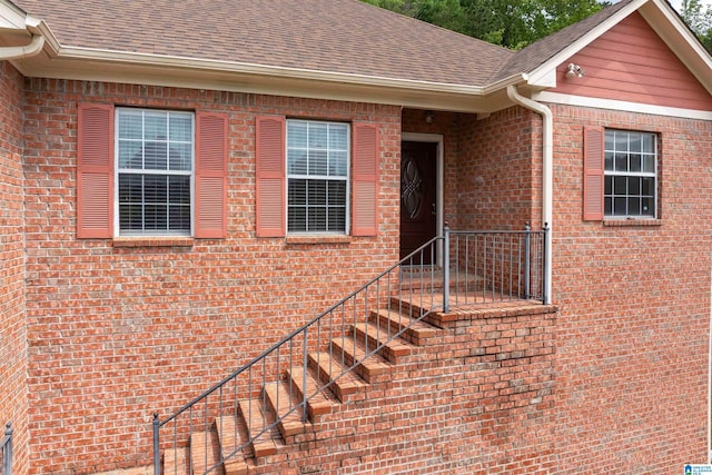 property entrance with brick siding and roof with shingles