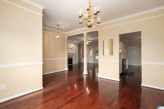 empty room with a fireplace, dark wood-type flooring, crown molding, baseboards, and ceiling fan with notable chandelier
