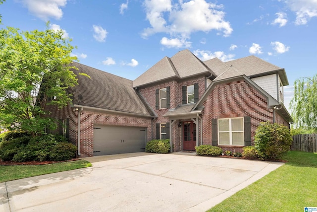 traditional-style house featuring brick siding, fence, roof with shingles, concrete driveway, and an attached garage