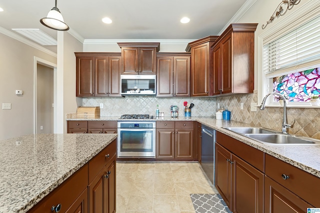 kitchen featuring appliances with stainless steel finishes, pendant lighting, tasteful backsplash, and a sink