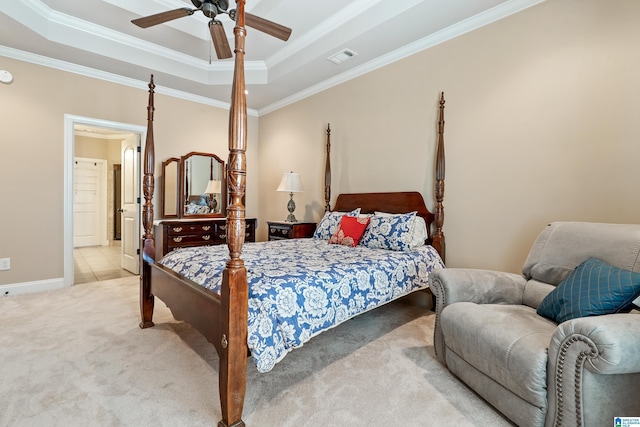 carpeted bedroom with a tray ceiling, a ceiling fan, visible vents, baseboards, and ornamental molding