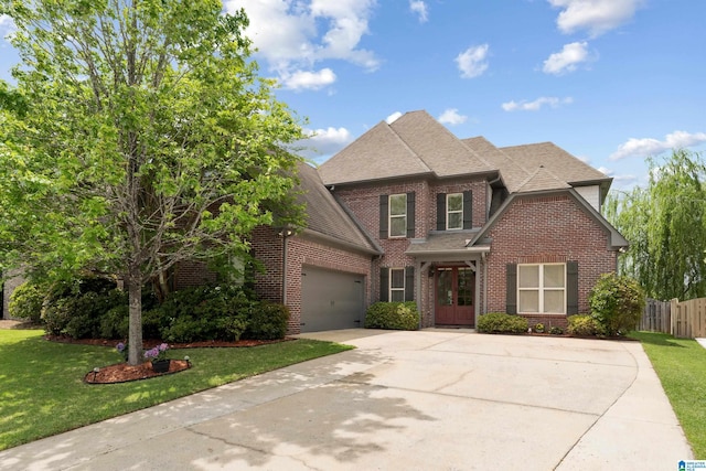 traditional-style house with driveway, roof with shingles, a front yard, and brick siding