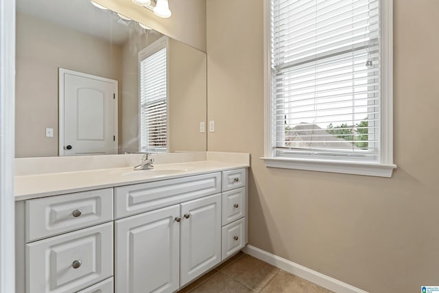 bathroom featuring a wealth of natural light, vanity, tile patterned flooring, and baseboards