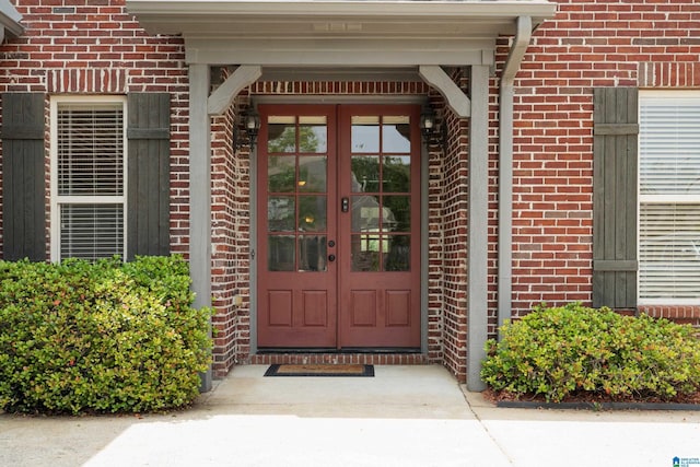 entrance to property featuring brick siding and french doors