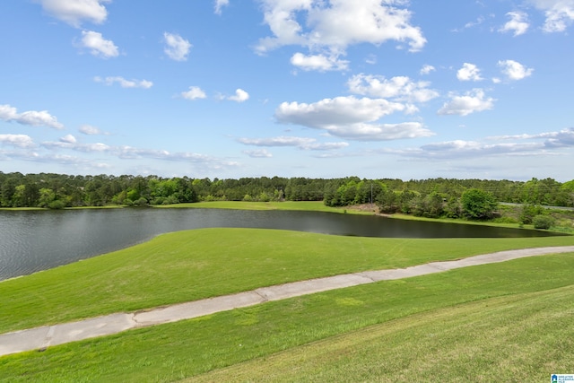 view of property's community featuring a yard, golf course view, a forest view, and a water view